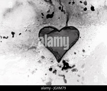 L'Ardoise coeur sur la fonte des glaces avec de l'encre se propager dans le corps creux de surface Banque D'Images