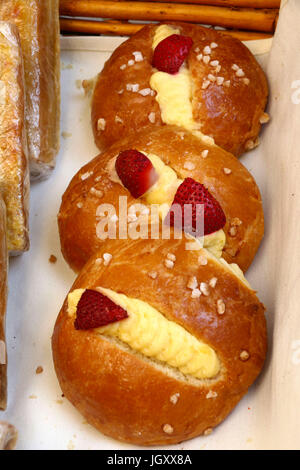 Français d'or sweet buns surmontée de fraises, Crème, sucre et vu à une foire de rue pour célébrer le Jour de la Bastille à Paris Banque D'Images