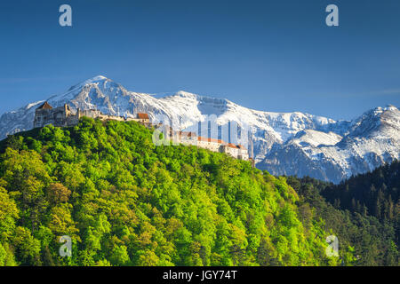 Étonnant Paysage de printemps avec la Forteresse de Rasnov et des montagnes de Bucegi enneigé en arrière-plan, la région de Brasov, en Transylvanie, Roumanie, Europe Banque D'Images