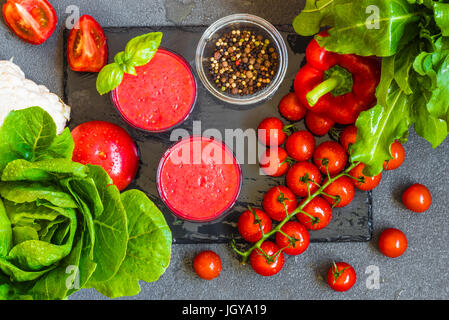 Tomate fraîche Smoothie Détox dans deux verres sur un fond gris. Banque D'Images