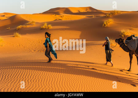 Conduit par la femme camel dunes de l'Erg Chebbi sur le Sahara dans l'est du Maroc Banque D'Images