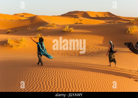 Conduit par la femme camel dunes de l'Erg Chebbi sur le Sahara dans l'est du Maroc Banque D'Images