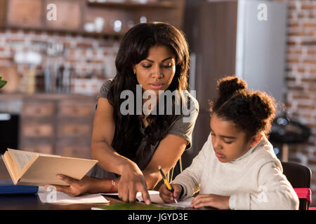 Mère et fille apprennent ensemble à table et faire leurs devoirs, concept d'aide aux devoirs Banque D'Images