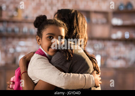 Vue de côté de la mère et de l'heureux daughter hugging chaque autres Banque D'Images