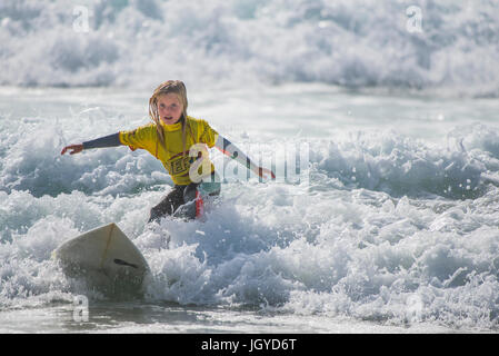 UK Surf. Enfant surf wave. Un surfeur de huit ans qui se font concurrence sur les écoles britanniques Championnat de Surf. Banque D'Images