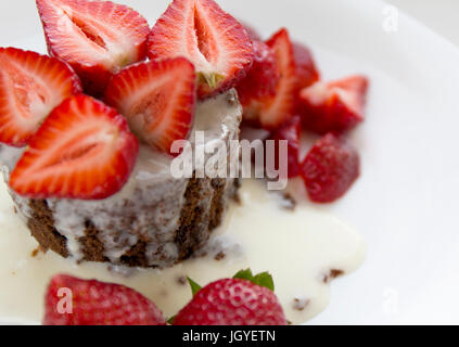 Délicieux gâteau au chocolat maison avec des fraises rouges frais et à la crème sur la plaque blanche. Banque D'Images