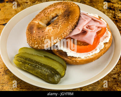 Jambon et fromage tomate bagel sésame avec cornichons assis sur un plateau de four Banque D'Images