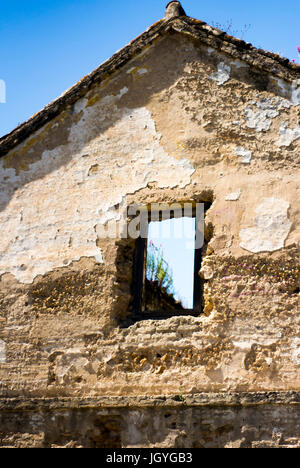 Maison en ruine fenêtre par laquelle vous pouvez voir le ciel bleu Banque D'Images