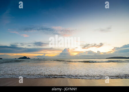 Belles vagues verser dans la plage pendant le coucher du soleil Banque D'Images