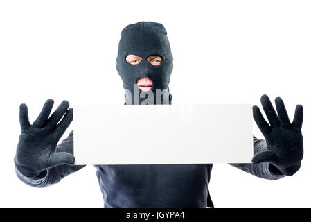 Voleur dans des vêtements noirs et un masque avec une affiche dans les mains sur un fond blanc Banque D'Images