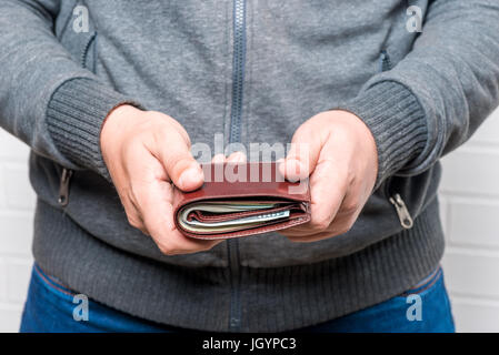 L'homme retient sa bourse avec de l'argent, les mains close-up Banque D'Images