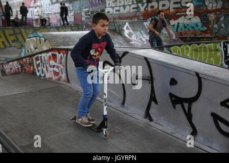 10-year-old boy riding a scooter dans un skate park France. Banque D'Images