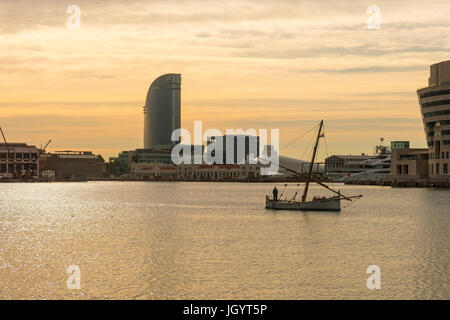 Lever du soleil dans le port de Barcelone, à la fin de Las Ramblas. Sur la photo, un bateau de pêche et voile hôtel. Barcelone, Espagne Banque D'Images