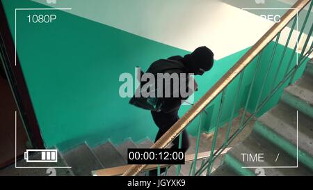 Surveillance Camera attrapé le voleur dans un masque d'exécution avec un sac de butin Banque D'Images