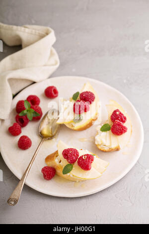 Face ouverte des sandwichs avec du fromage, de poires et de framboises Banque D'Images