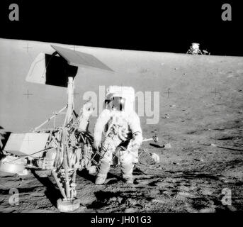 Conrad et arpenteur sur la pente d'un cratère. Charles Conrad Jr., commandant de la mission Apollo 12, examine l'engin spatial non habité Surveyor III pendant la seconde activité extravéhiculaire (EVA-2). Le Module lunaire (LM) 'Intrepid' est dans l'arrière-plan droit. Cette photo a été prise par l'astronaute Alan Bean L., pilote du module lunaire. L 'Intrepid' s'est posé sur la Lune's Ocean des tempêtes à seulement 600 pieds de Surveyor III. La caméra de télévision et plusieurs autres composants ont été prises à partir de Surveyor III et ramenés à terre pour l'analyse scientifique. Surveyor III soft à l'atterrissage sur la lune le 19 avril 1967. Banque D'Images