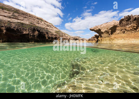 Un split shot d'une piscine dans les rochers sur une côte isolée dans le sud de l'Australie. Banque D'Images