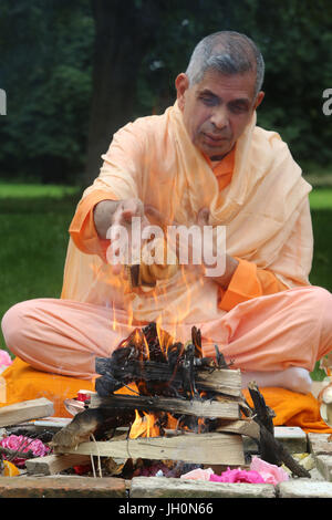 Swami Veetamohanda effectuant l'homa rituel du feu dans le jardin de la centre védantique Ramakrishna. Gretz. La France. Banque D'Images