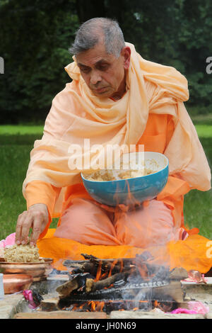 Swami Veetamohanda effectuant l'homa rituel du feu dans le jardin de la centre védantique Ramakrishna. Gretz. La France. Banque D'Images