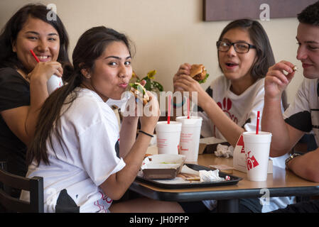 Chick-fil-A fans appréciant un repas avec des amis sur la Journée de reconnaissance de la vache à Chick-fil-A, America's top-rated restaurant fast food. Banque D'Images