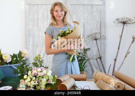 Long haired woman with bouquet à mains flower shop Banque D'Images