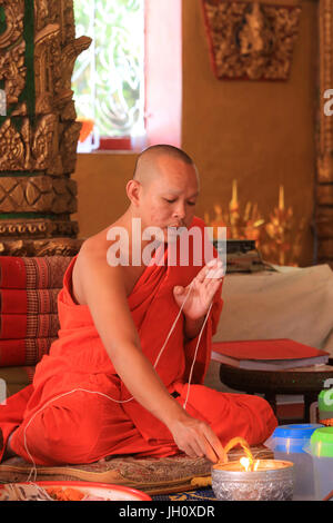 Sai le péché. Fil de coton symbolisant le lien sacré. Cérémonie bouddhiste. Vat Simuong. Wat Si Muang. Vientiane. Le Laos. Banque D'Images