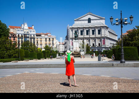 Femme dans une robe rouge debout devant le Teatro Real / Theatre Royal et le monument à Felipe IV à Madrid Espagne Banque D'Images