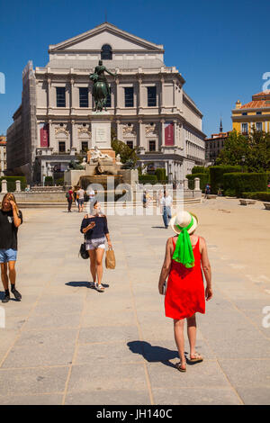 Femme dans une robe rouge debout devant le Teatro Real / Theatre Royal et le monument à Felipe IV à Madrid Espagne Banque D'Images