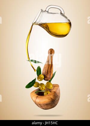 Avec le vol de l'huile d'olive olives dans bol en bois, concept d'une saine alimentation. Studio photo en haute résolution. Le régime alimentaire et l'alimentation santé et mode de vie. Séparer Banque D'Images