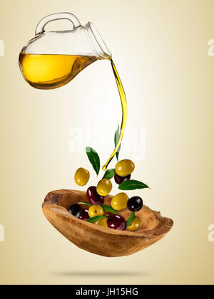 Avec le vol de l'huile d'olive olives dans bol en bois, concept d'une saine alimentation. Studio photo en haute résolution. Le régime alimentaire et l'alimentation santé et mode de vie. Séparer Banque D'Images