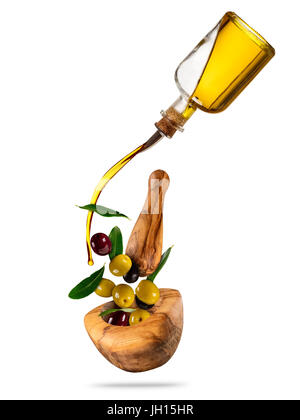 Avec le vol de l'huile d'olive olives en mortier en bois, concept d'une saine alimentation. Studio photo en haute résolution. Le régime alimentaire et l'alimentation santé et mode de vie. Séparation Banque D'Images