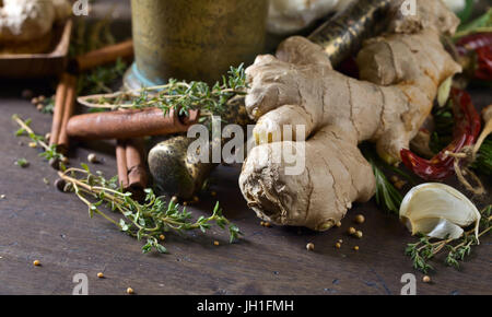 Le gingembre avec épices et fines herbes sur une table de cuisine. Banque D'Images