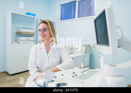 Smiling doctor, échographie. Le médecin effectue une échographie. Banque D'Images