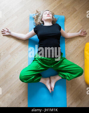 D'âge moyen ou mature woman doing yoga indoors Banque D'Images