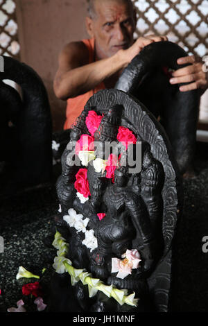Temple Hindou dévot de placer des fleurs sur murthis Raman en reti. L'Inde. Banque D'Images