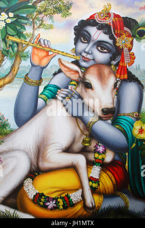 Peinture représentant dieu hindou Krishna jouant de la flûte et se caresser un veau. L'Inde. Banque D'Images