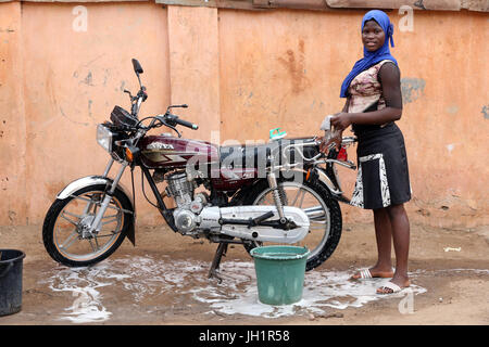 Femme lave-moto. Lome. Le Togo. Banque D'Images