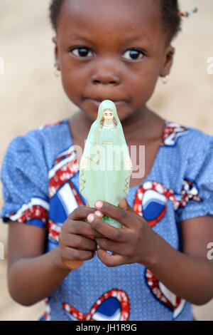 African girl holding Vierge Marie statue. Lome. Le Togo. Banque D'Images