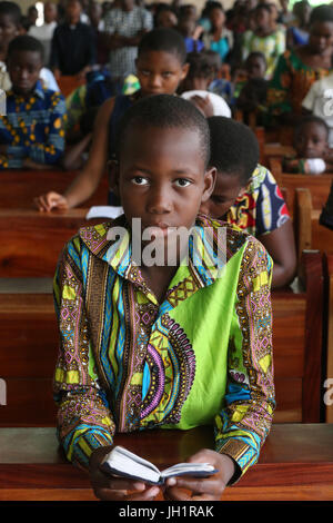 Dimanche matin messe catholique. Jeune garçon Lisant la bible. Lome. Le Togo. Banque D'Images