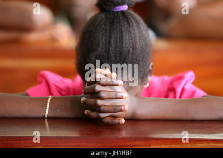 Dimanche matin messe catholique. Jeune fille en prière. Lome. Le Togo. Banque D'Images