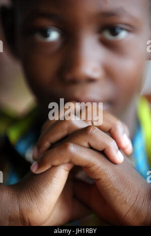 Dimanche matin messe catholique. Jeune garçon en train de prier. Lome. Le Togo. Banque D'Images