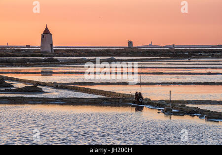 Coucher du soleil sur le sel et les moulins à vent de la faune à la réserve près de la Nubie, au sud de Trapani, sur la côte ouest de la Sicile, en Italie. Banque D'Images