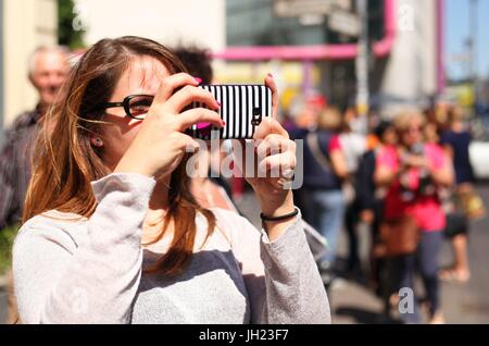 Une femme prend des photos touristiques avec son téléphone portable à Checkpoint Charlie dans le centre de Berlin le 02 juin 2017. Cette image fait partie d'une série de photos sur le tourisme à Berlin. Photo : Wolfram Steinberg/dpa | conditions dans le monde entier Banque D'Images