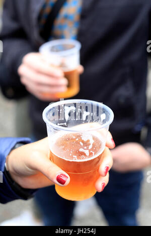 Couple de boire une bière en verre plastique. La France. Banque D'Images