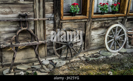 Un détail d'une vieille maison en bois rustique et roues de charrette Banque D'Images