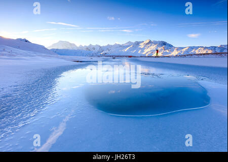 Photographe admire Lake, Piz Umbrail à l'aube avec le Mont Ortles en arrière-plan, la vallée de la Valteline, Braulio, Lombardie, Italie Banque D'Images