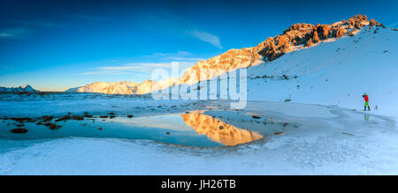 Panorama du lac, le Piz Umbrail à l'aube avec le photographe en action encadrée par la neige, la vallée de la Valteline, Braulio, Lombardie, Italie Banque D'Images