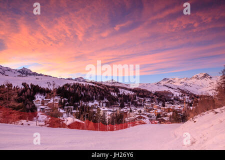 Les nuages roses au coucher du soleil sur le village alpin de Madesimo et les pistes de ski enneigées, la vallée de la Valteline, Cf alpina, Lombardie, Italie Banque D'Images
