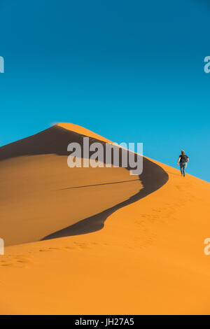 Femme de randonnée du giant Sand Dune 45, Sossusvlei, Namib-Naukluft National Park, Namibie, Afrique Banque D'Images