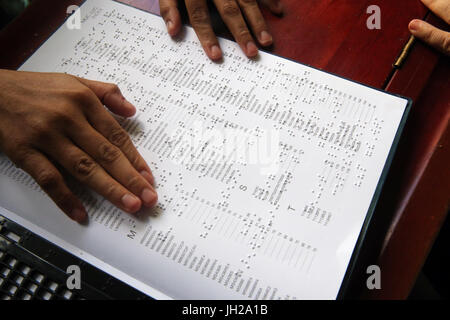 Le Vietnam. Centre pour enfants aveugles. Girl reading braille. Banque D'Images